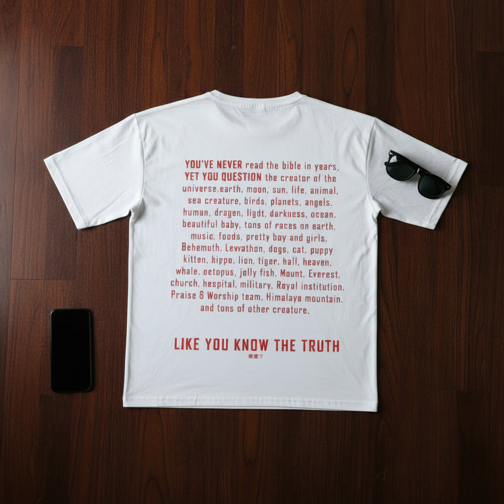 White t-shirt with red text on a wooden surface with sunglasses and phone. long text. LIKE YOU KNOW THE TRUTH 